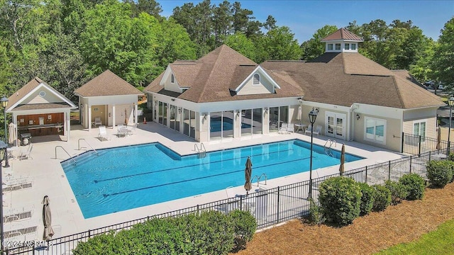 community pool featuring a patio area and fence