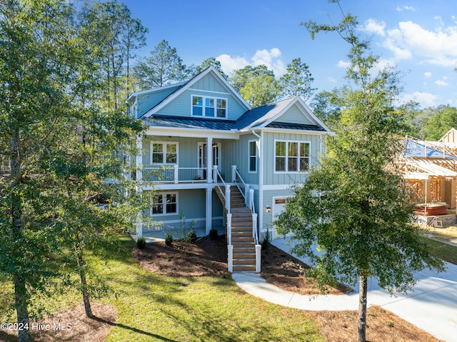 3617 Barnesmore Dr, Castle Hayne, NC 28429 - view of front of property featuring board and batten siding, stairway, covered porch, a standing seam roof, and metal roof