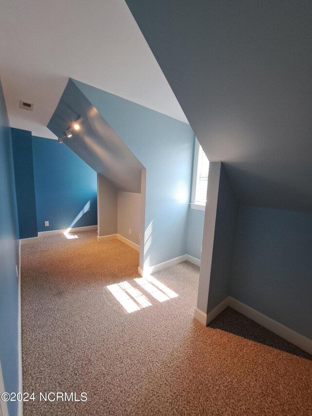 bonus room featuring lofted ceiling and carpet