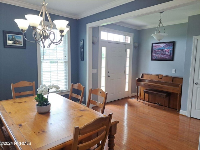 dining area featuring a notable chandelier, crown molding, and hardwood / wood-style floors