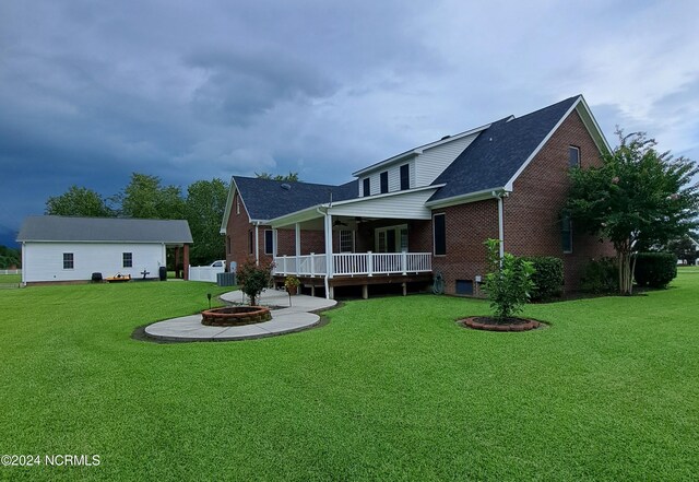 rear view of house with a patio, an outdoor fire pit, and a lawn