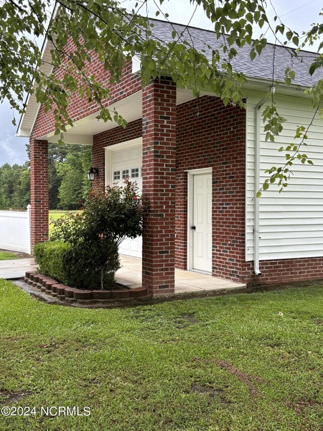 entrance to property with a garage and a yard