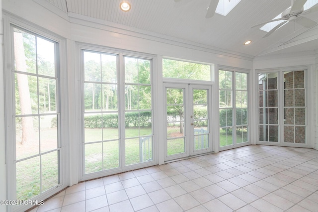 unfurnished sunroom with ceiling fan and lofted ceiling with skylight