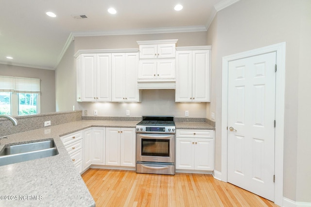 kitchen featuring stainless steel range, white cabinetry, ornamental molding, and sink