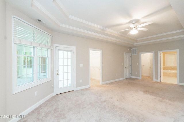 spare room featuring ceiling fan, a raised ceiling, light carpet, and crown molding