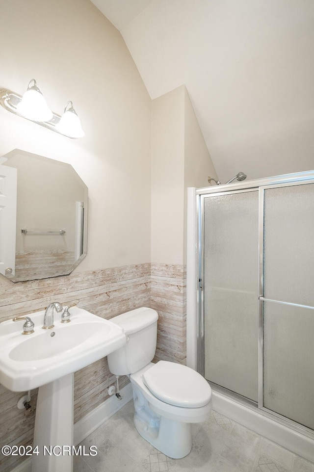 bathroom featuring sink, an enclosed shower, lofted ceiling, toilet, and tile walls