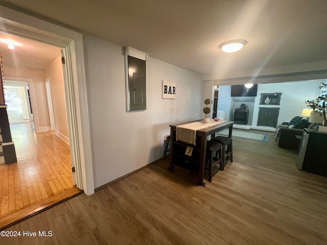 dining space with dark hardwood / wood-style flooring, electric panel, and a fireplace