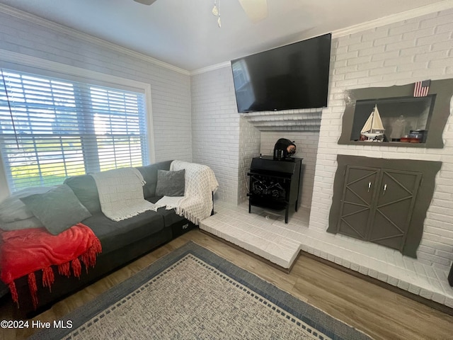 living room with ceiling fan, dark hardwood / wood-style floors, brick wall, and ornamental molding