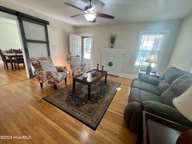 living room featuring light hardwood / wood-style floors, ceiling fan, and plenty of natural light