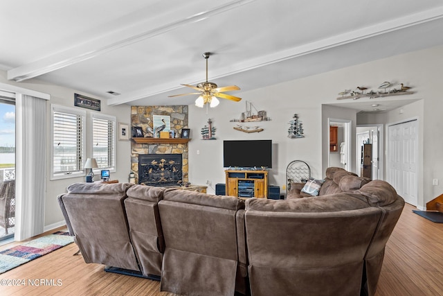 living room with hardwood / wood-style floors, beam ceiling, a fireplace, and ceiling fan