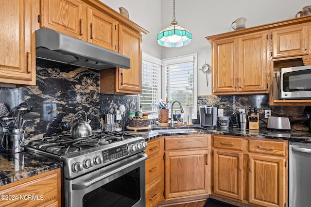 kitchen featuring backsplash, appliances with stainless steel finishes, sink, and pendant lighting