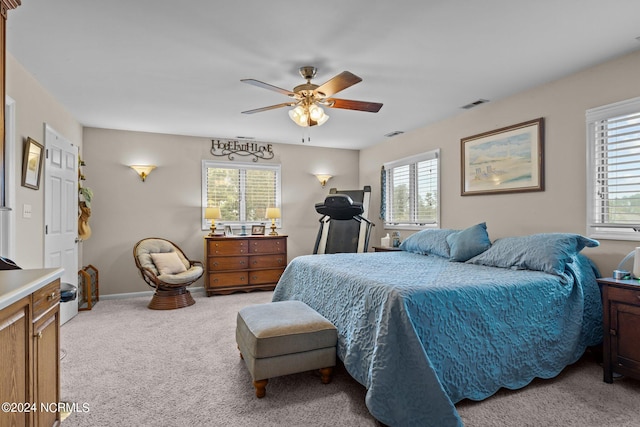 bedroom with ceiling fan, multiple windows, and light colored carpet