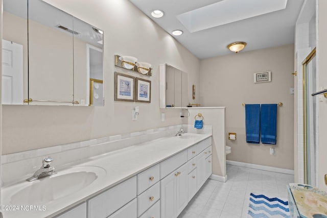 bathroom featuring toilet, tile patterned flooring, vanity, a skylight, and an enclosed shower