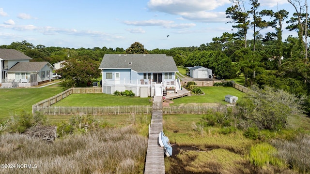 back of property featuring a wooden deck and a lawn