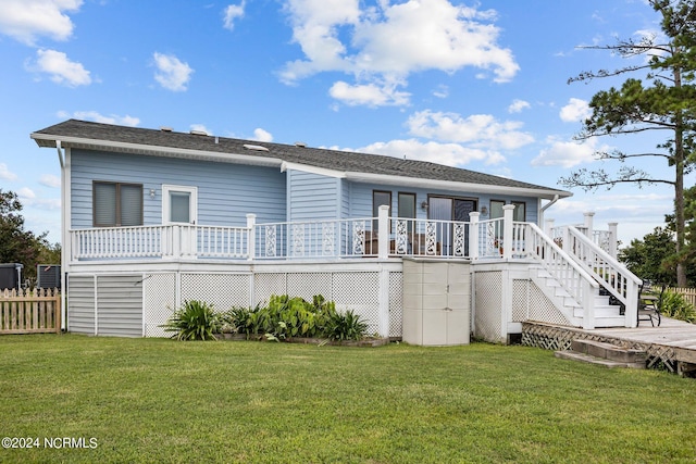 rear view of house featuring a wooden deck and a yard