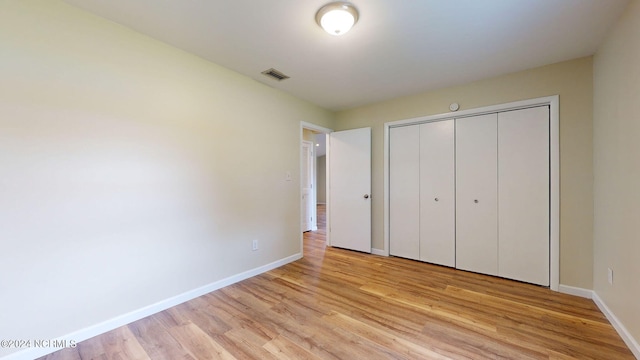 unfurnished bedroom with light hardwood / wood-style floors and a closet