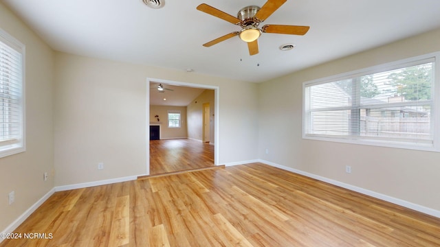 spare room featuring ceiling fan, a healthy amount of sunlight, and light wood-type flooring