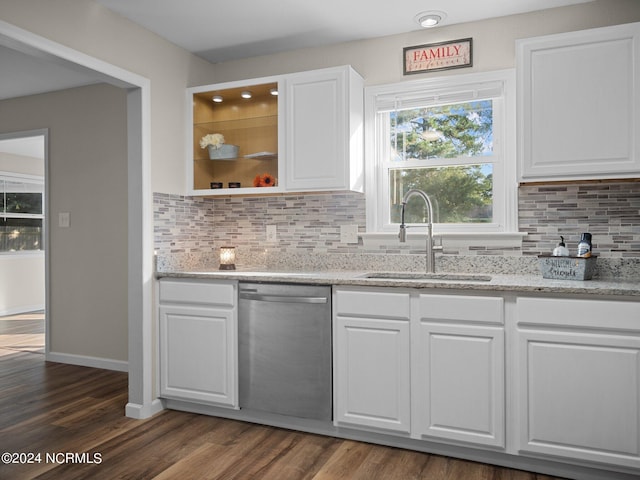 kitchen with dark wood-style floors, stainless steel dishwasher, a sink, and white cabinets
