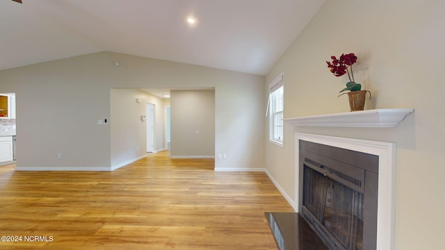 unfurnished living room with light hardwood / wood-style floors and lofted ceiling