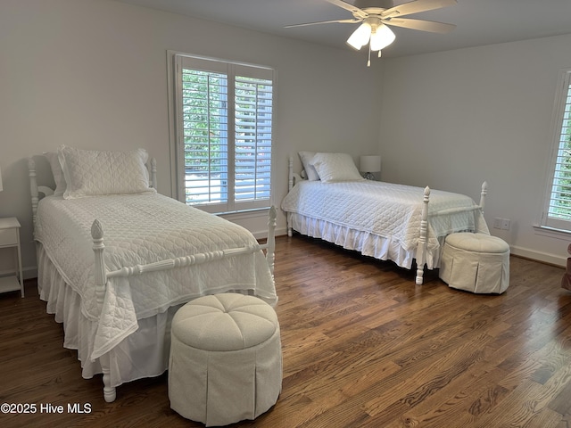 bedroom with baseboards, multiple windows, and wood finished floors