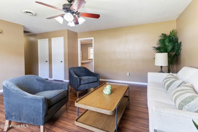 living room with ceiling fan and dark wood-type flooring