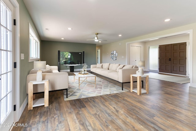 living room with dark hardwood / wood-style flooring and ceiling fan