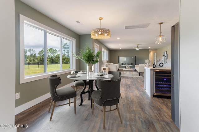 dining area with ceiling fan with notable chandelier, dark hardwood / wood-style floors, and wine cooler