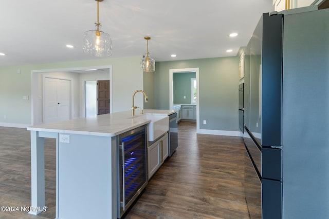 kitchen with a kitchen island with sink, refrigerator, sink, hanging light fixtures, and beverage cooler