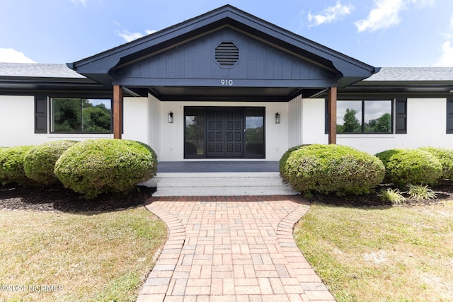 property entrance with a lawn and a porch