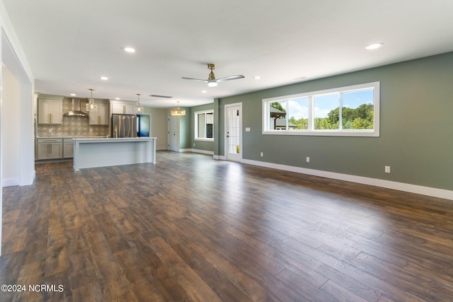 unfurnished living room featuring ceiling fan and dark wood-type flooring