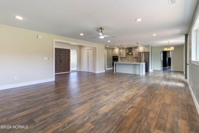 unfurnished living room featuring ceiling fan and dark wood-type flooring