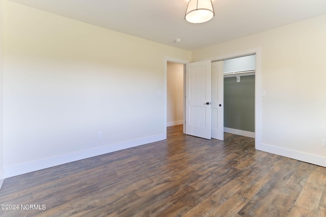 unfurnished bedroom featuring a closet and dark hardwood / wood-style flooring