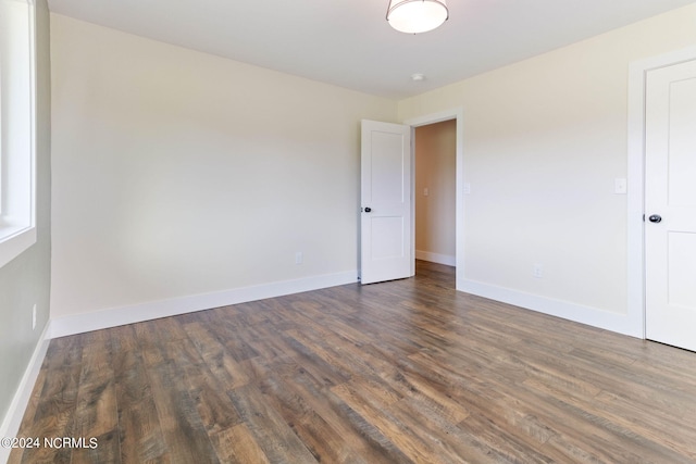 empty room with dark hardwood / wood-style flooring