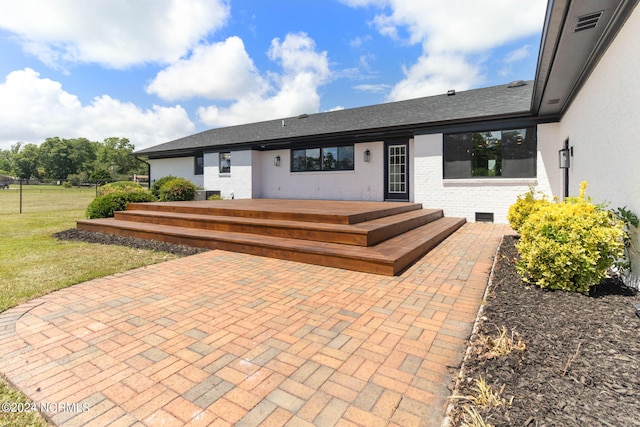 exterior space featuring a deck, a patio, and a front yard