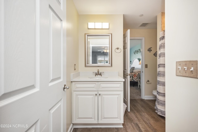 bathroom featuring ceiling fan, vanity, wood-type flooring, and toilet