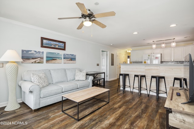 living room with ceiling fan, dark hardwood / wood-style floors, and ornamental molding