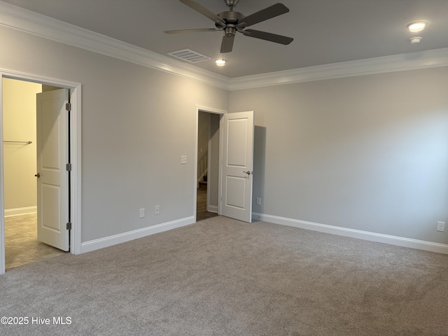 carpeted empty room with ceiling fan and crown molding