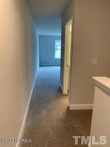 hallway with dark colored carpet