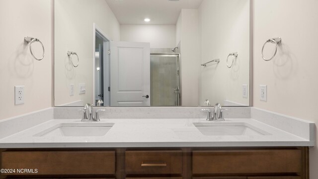 bathroom featuring vanity and a shower with shower door