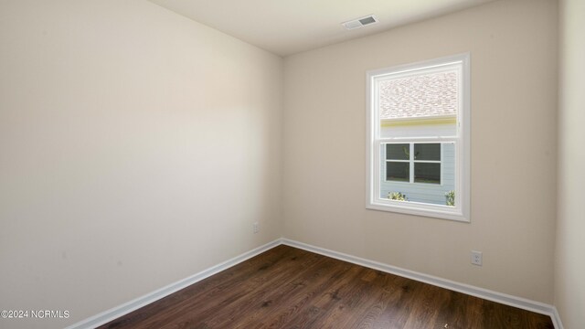 empty room with dark hardwood / wood-style flooring