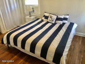 bedroom with dark wood-type flooring