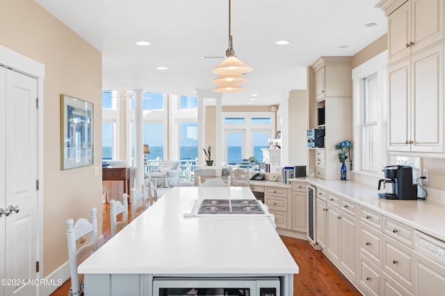 kitchen featuring white appliances, beverage cooler, pendant lighting, a water view, and dark hardwood / wood-style floors