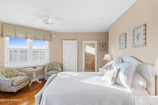 bedroom featuring ceiling fan, wood-type flooring, and ensuite bath