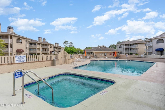 view of swimming pool with a patio and a hot tub