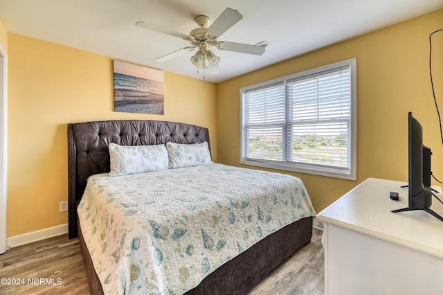 bedroom with a ceiling fan, baseboards, and wood finished floors