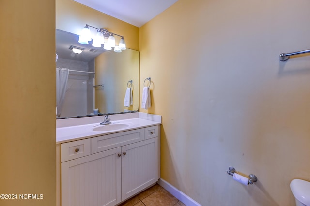 full bathroom featuring curtained shower, toilet, vanity, baseboards, and tile patterned floors