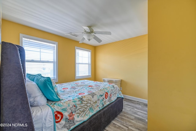 bedroom featuring a ceiling fan, baseboards, and wood finished floors