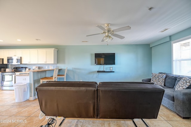 living room with a ceiling fan, light tile patterned flooring, and visible vents