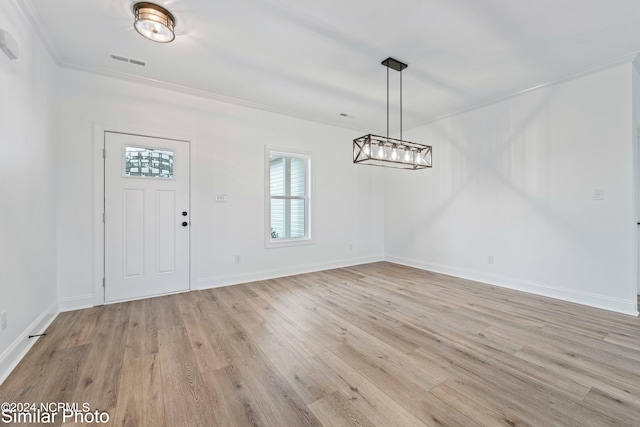 entrance foyer featuring light hardwood / wood-style flooring and crown molding