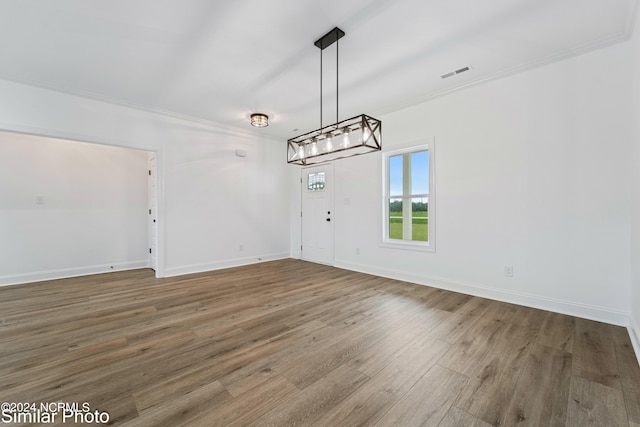 unfurnished dining area featuring wood-type flooring and ornamental molding